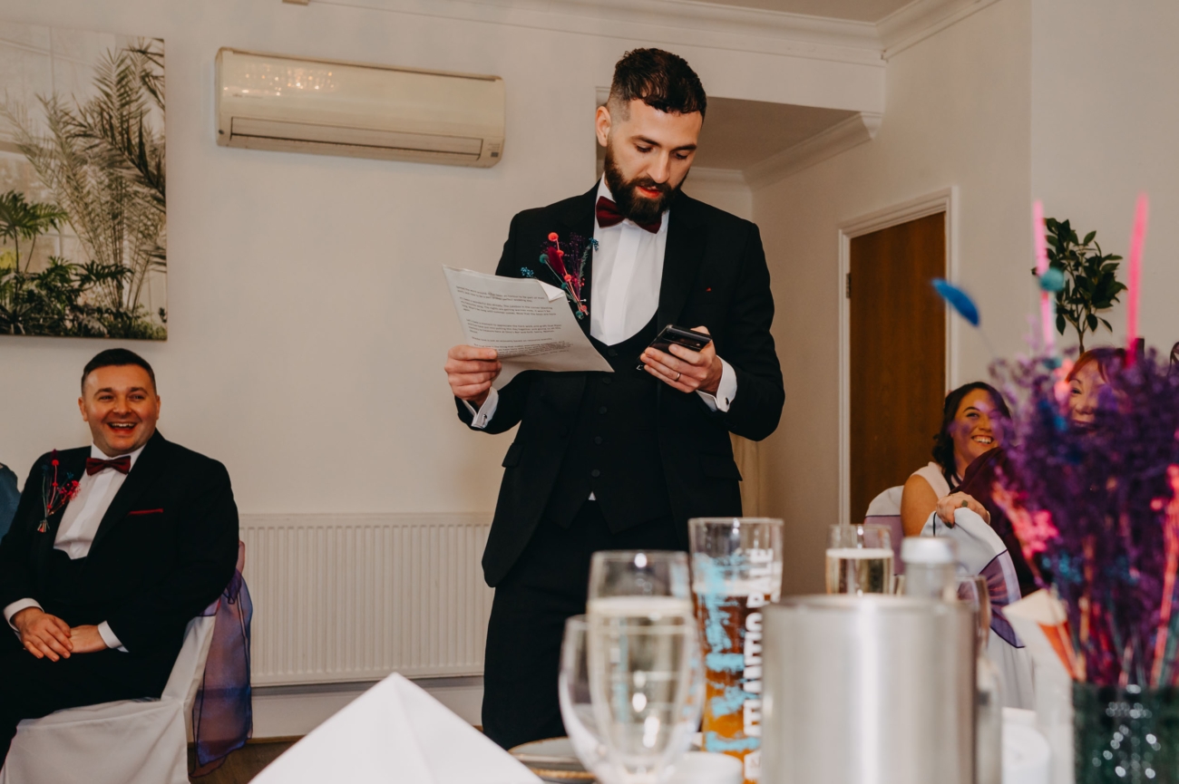 Best man reading his speech during the wedding reception captured in documentary wedding photography style