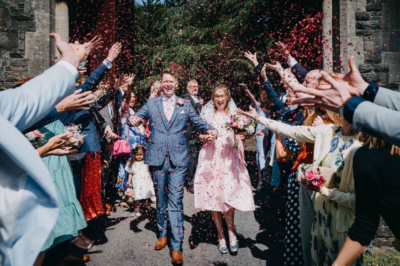 Wedding couple walking through confetti after their ceremony