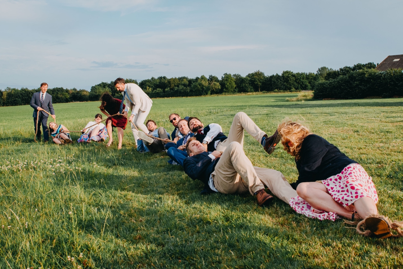 guests falling during tug of war at a festival wedding with spontaneous chaotic energy