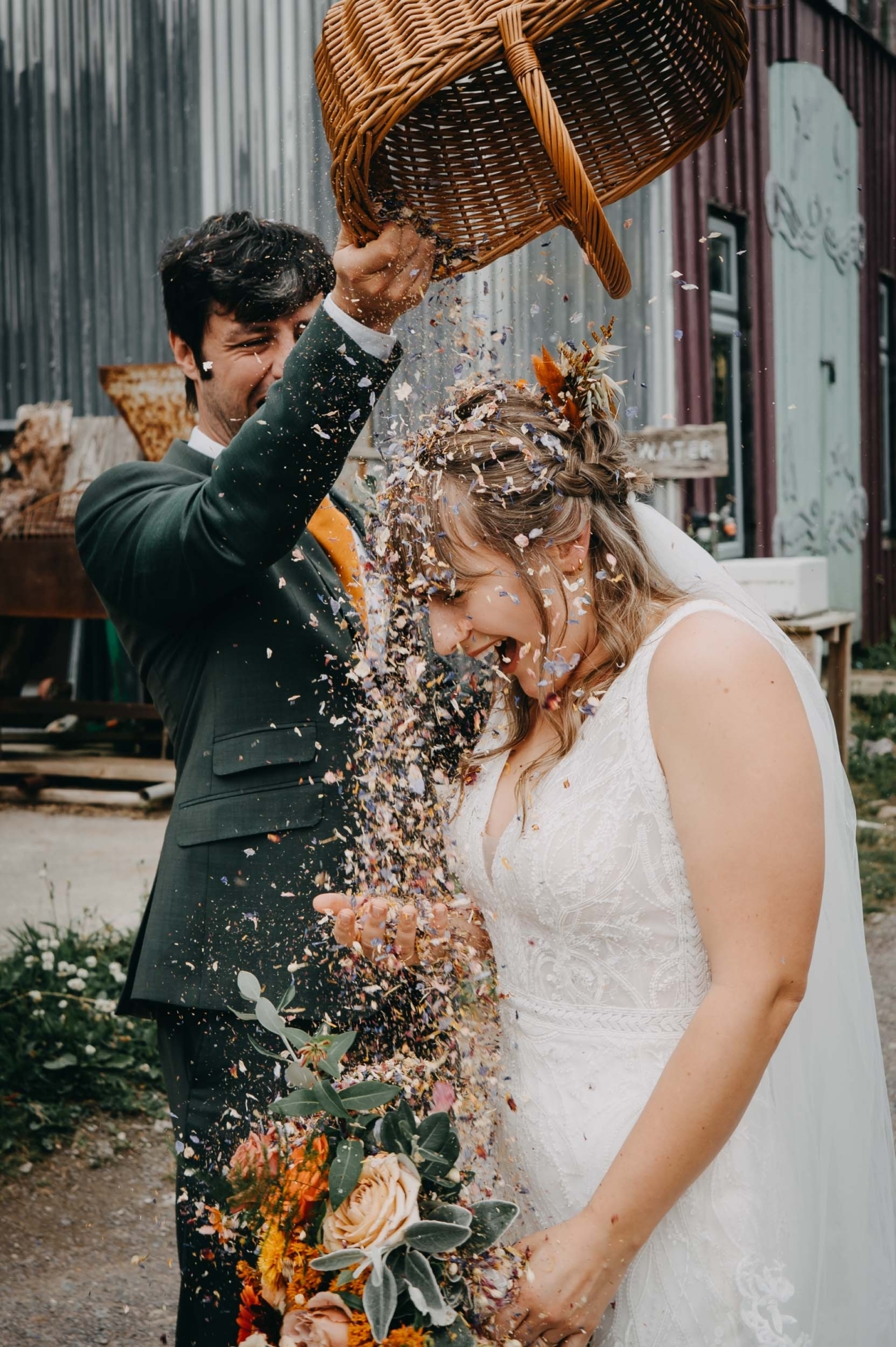 Bride laughing as confetti is thrown over her during a wedding celebration