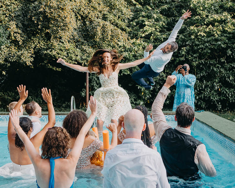fun candid wedding moment in South Wales guests celebrating by the pool
