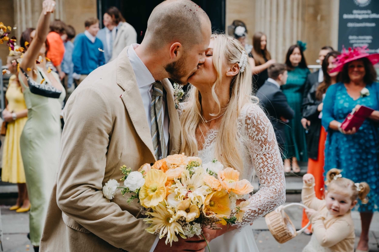 Candid wedding photography of a couple kissing outside Bristol Registry Office with confetti captured by a Bristol wedding photographer