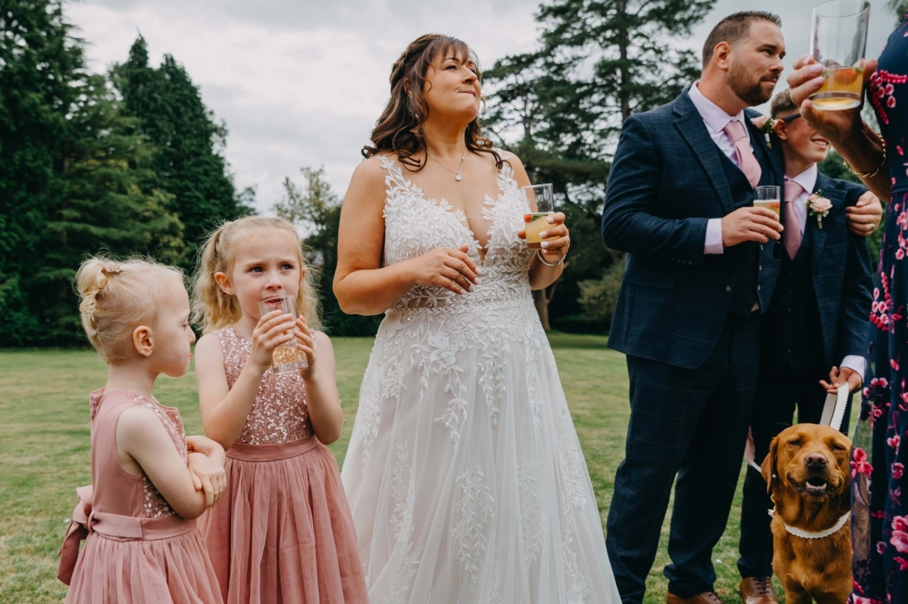 Candid wedding photography of a bride with guests and children at Pennard House in Somerset captured by a Bristol wedding photographer