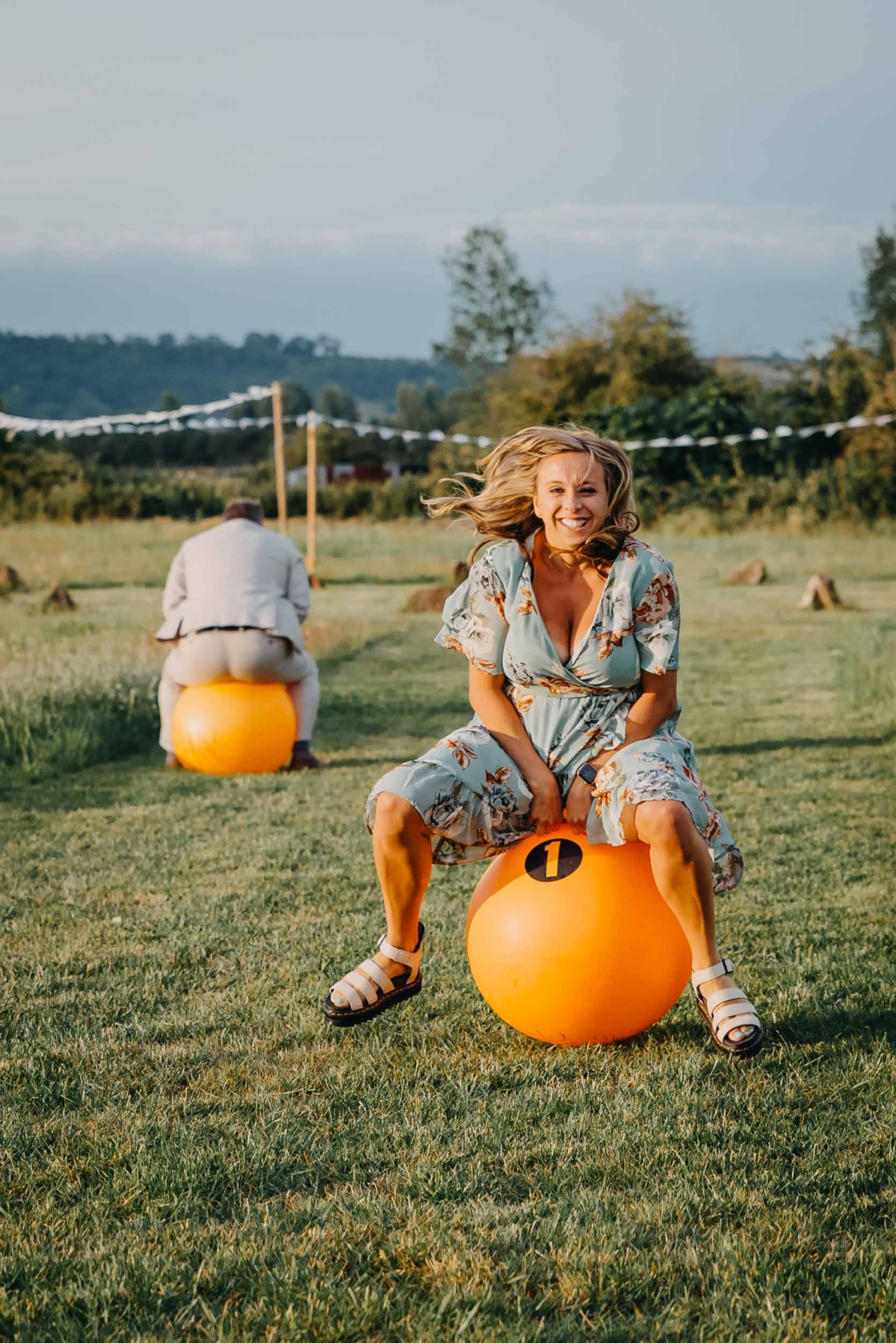 Documentary wedding photography capturing a space hopper race during a festival wedding in Glastonbury