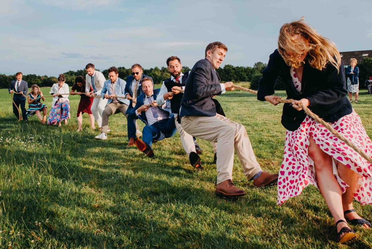 Documentary wedding photography capturing a tug of war game during a festival wedding in Glastonbury