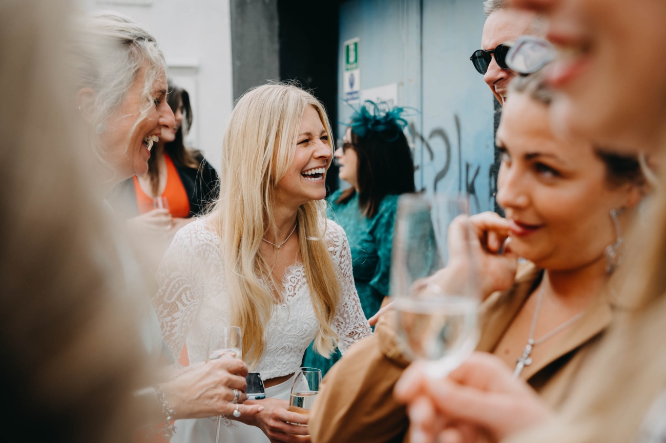 Natural wedding photography of a bride laughing with guests at The Forge in Bristol captured by a Bristol wedding photographer