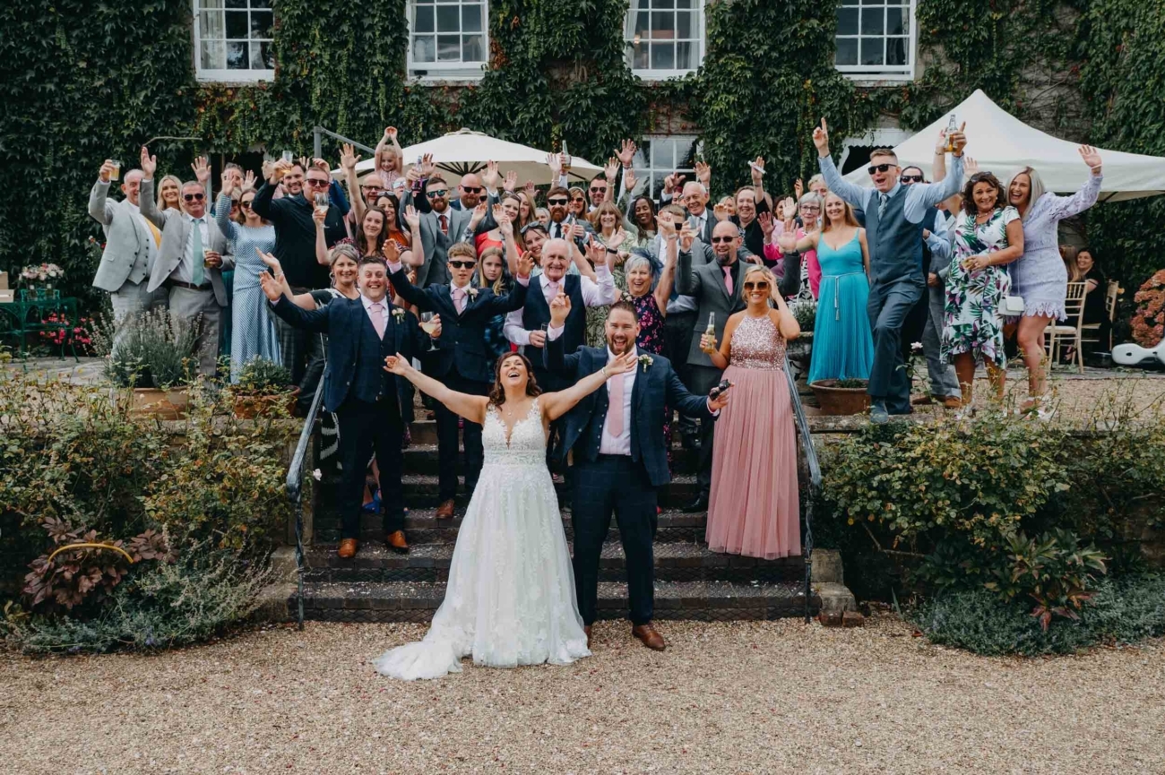 Relaxed wedding group photo full of energy at Pennard House in Somerset