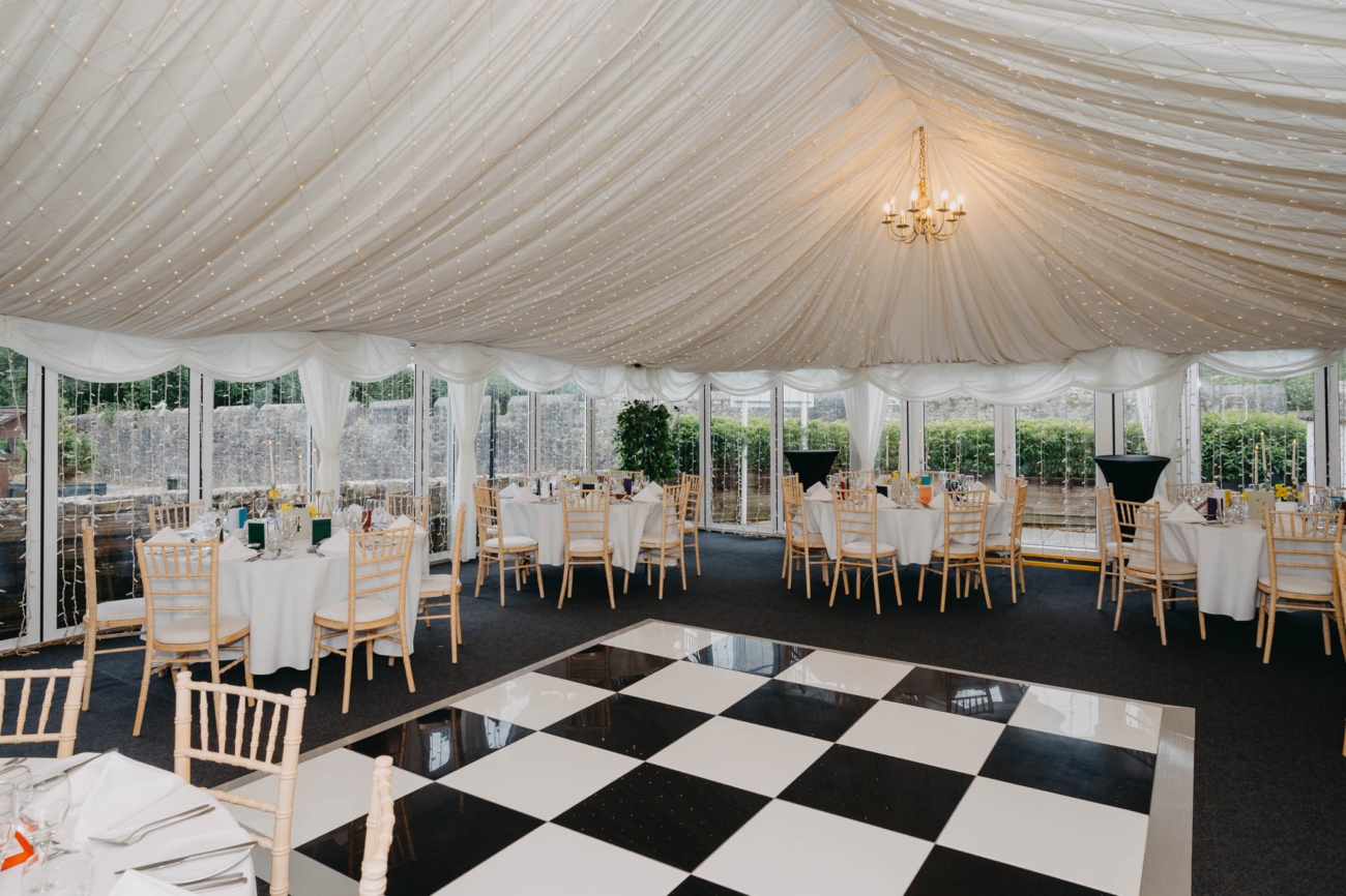 Wedding reception marquee at Old Post House in St Fagans, Cardiff, with tables, fairy lights and dance floor
