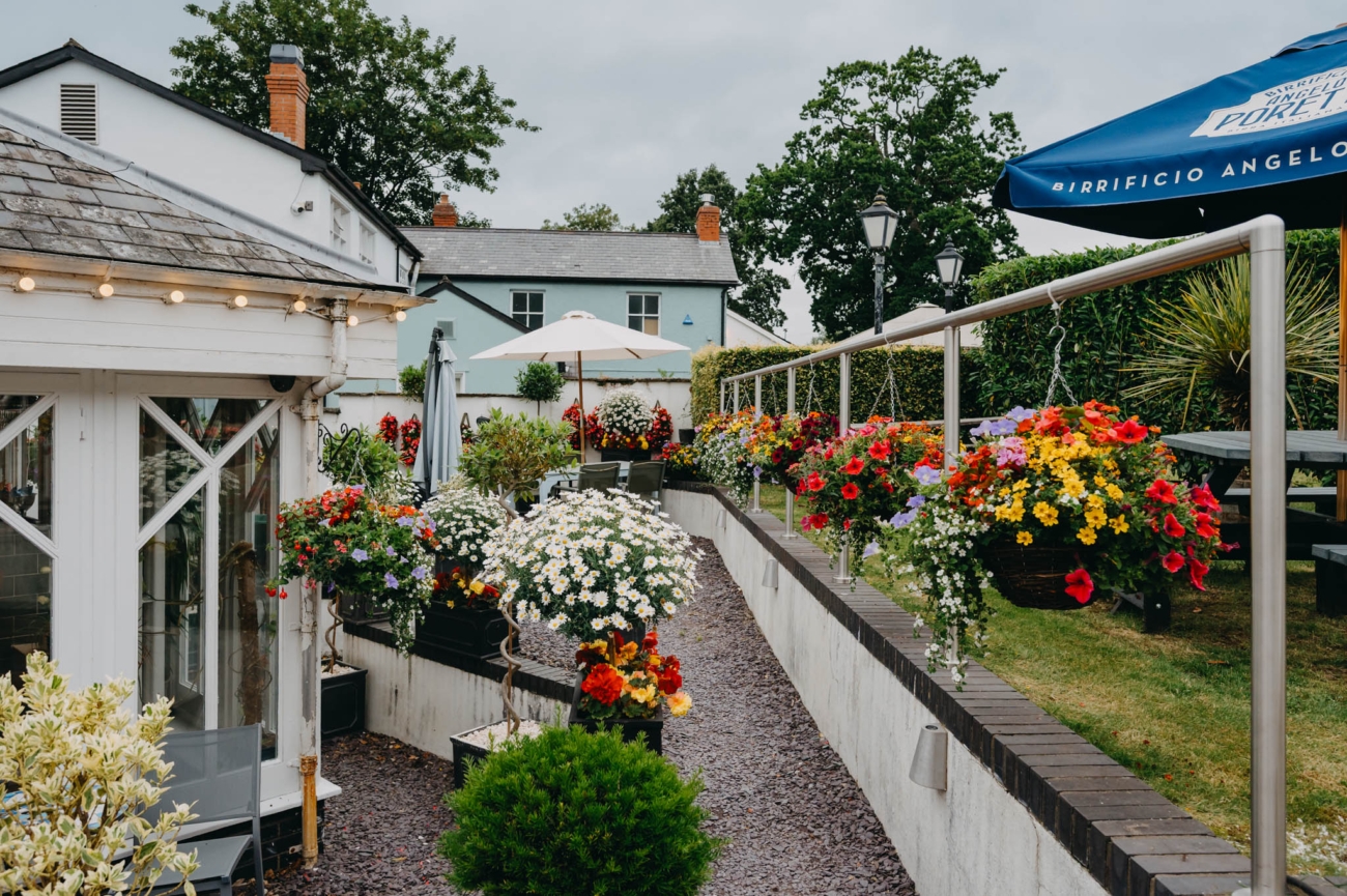 Garden at Old Post House wedding venue in Cardiff with colourful flowers and outdoor seating