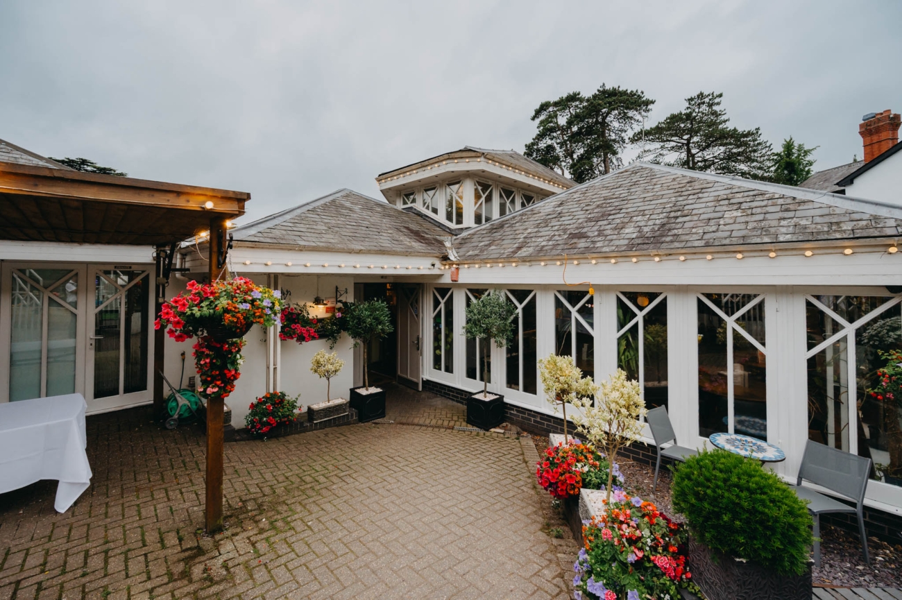 Courtyard at Old Post House wedding venue in St Fagans, Cardiff, decorated with colourful flowers