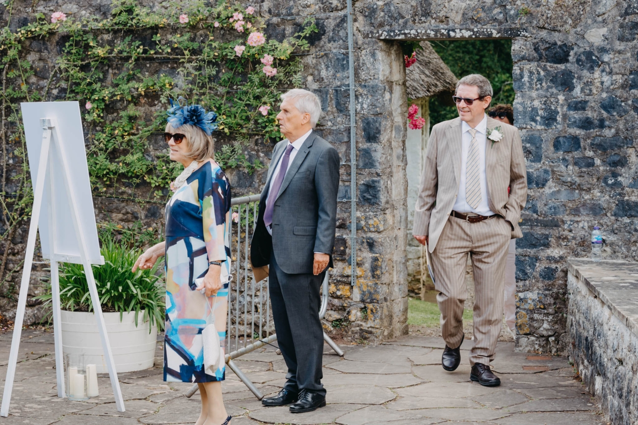 Wedding guests arriving through the stone entrance to the Italian Gardens at St Fagan