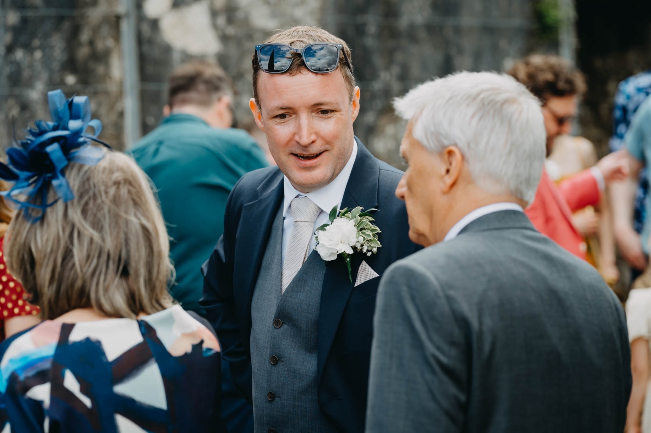 Groom chatting with guests before the outdoor wedding ceremony
