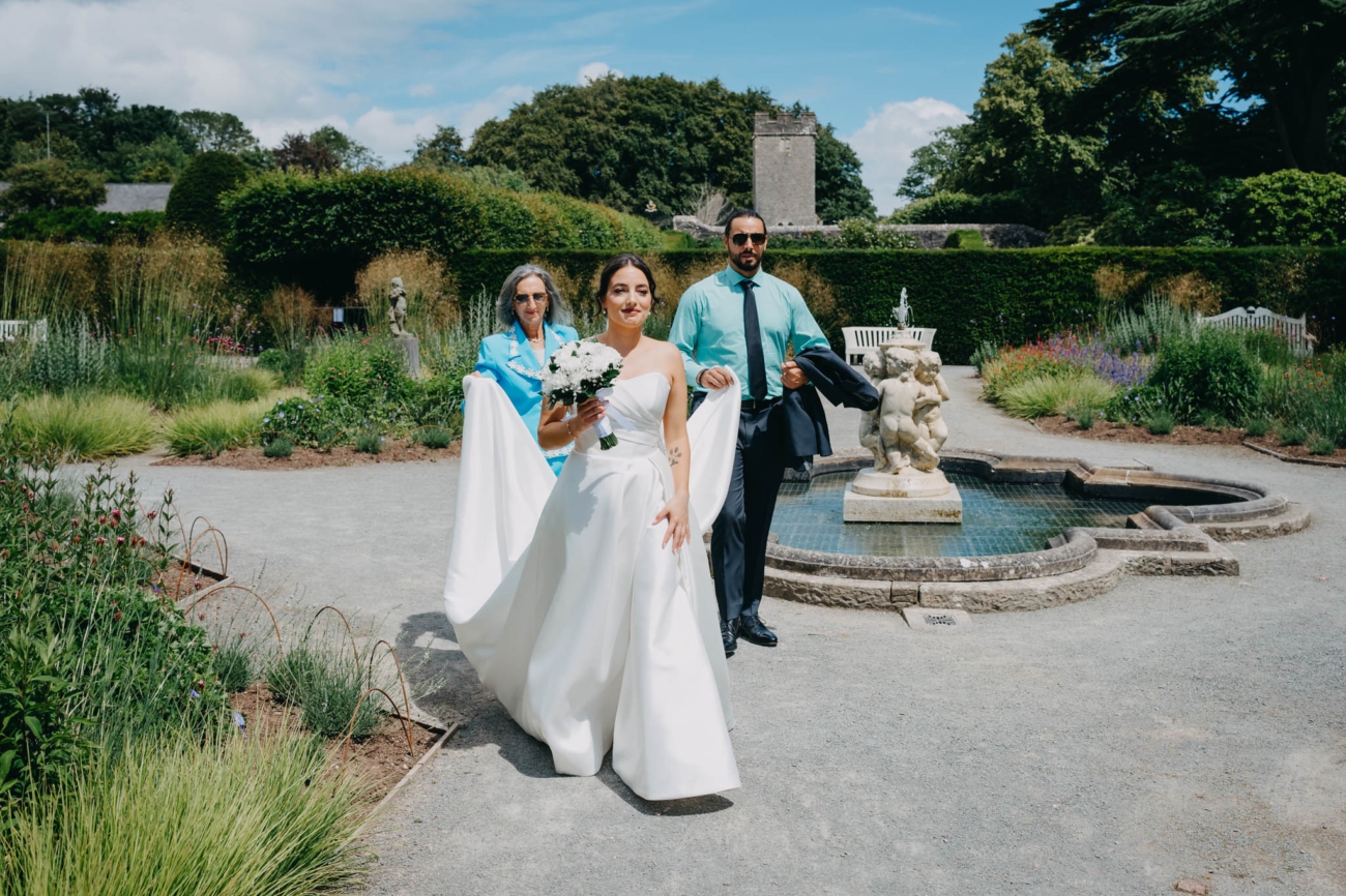 Bride crossing the Italian Gardens with family members on her way to the outdoor ceremony
