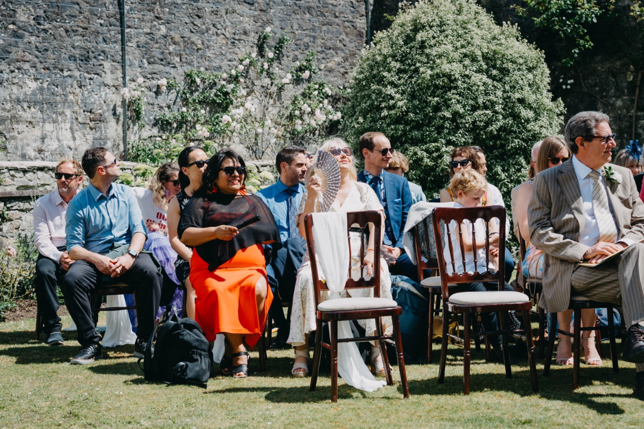 Wedding guests chatting in the sunshine before the Italian Gardens ceremony