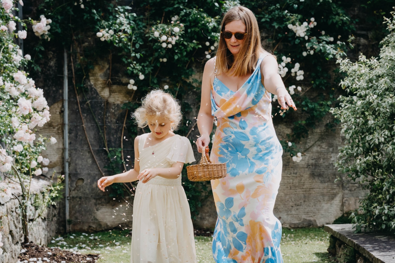 Flower girl scattering petals as she walks into the Italian Gardens wedding ceremony
