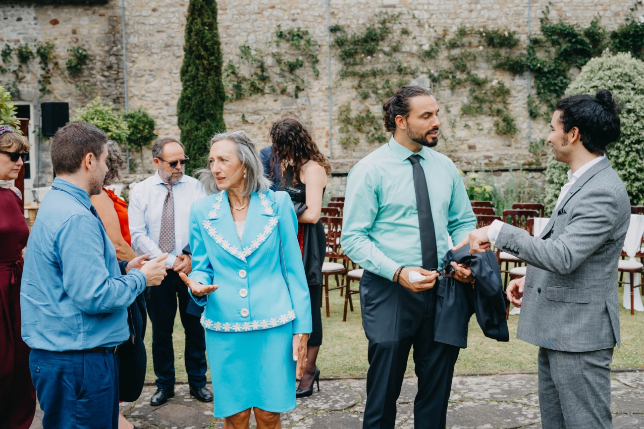 Wedding guests chatting after the outdoor ceremony in the Italian Gardens at St Fagans