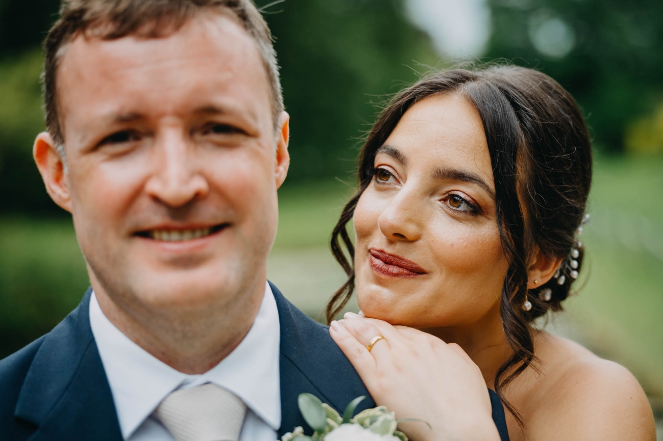 Bride resting her chin on the groom’s shoulder during a close wedding portrait