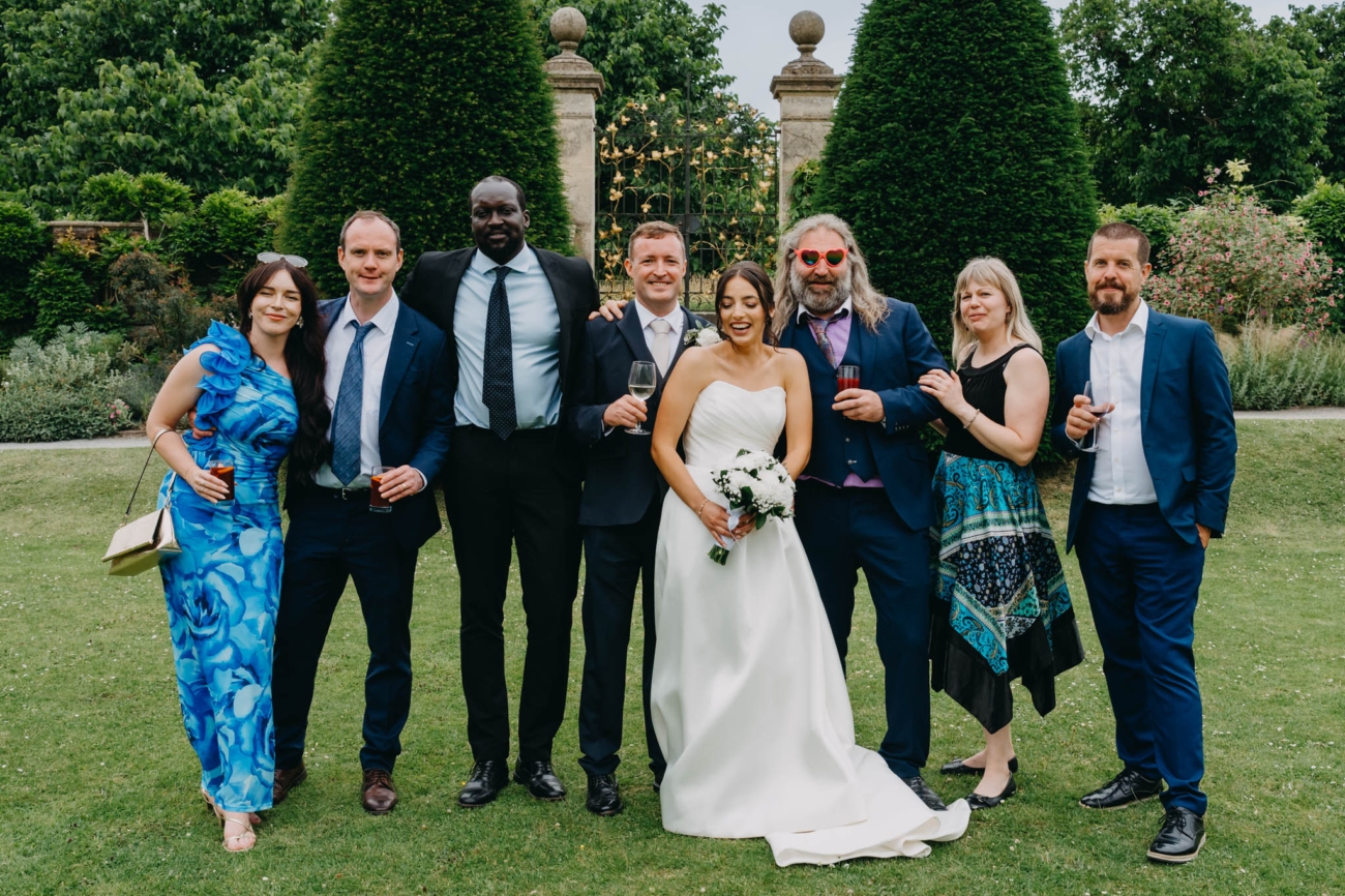 Bride and groom posing with a group of wedding guests in the Italian Gardens