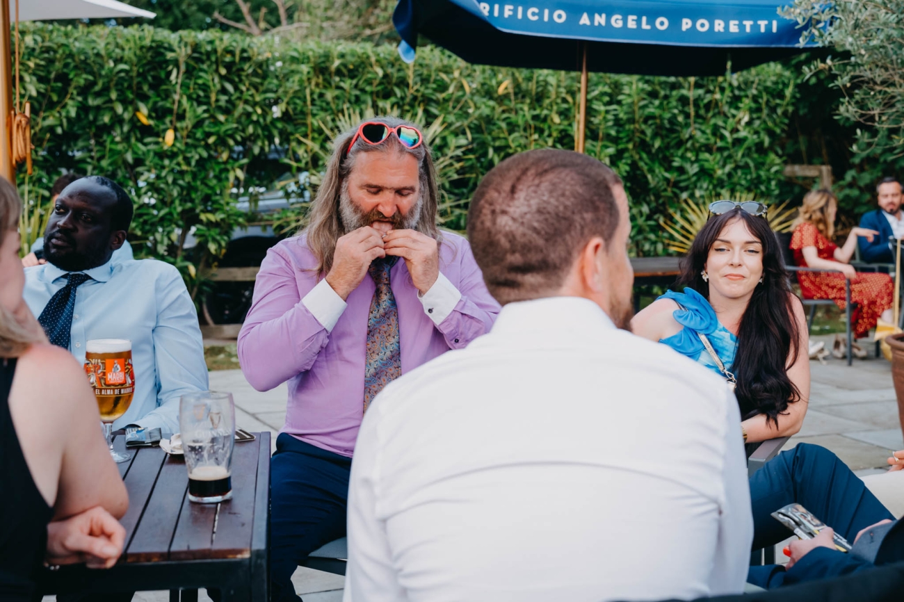 Wedding guests relaxing together around an outdoor table on the Old Post House terrace