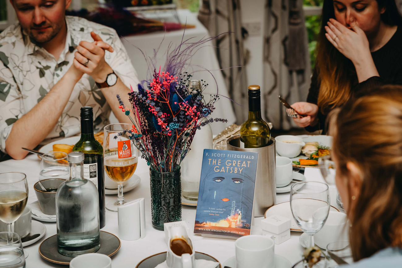 The Great Gatsby by F. Scott Fitzgerald displayed as a wedding table centrepiece with colourful floral decorations